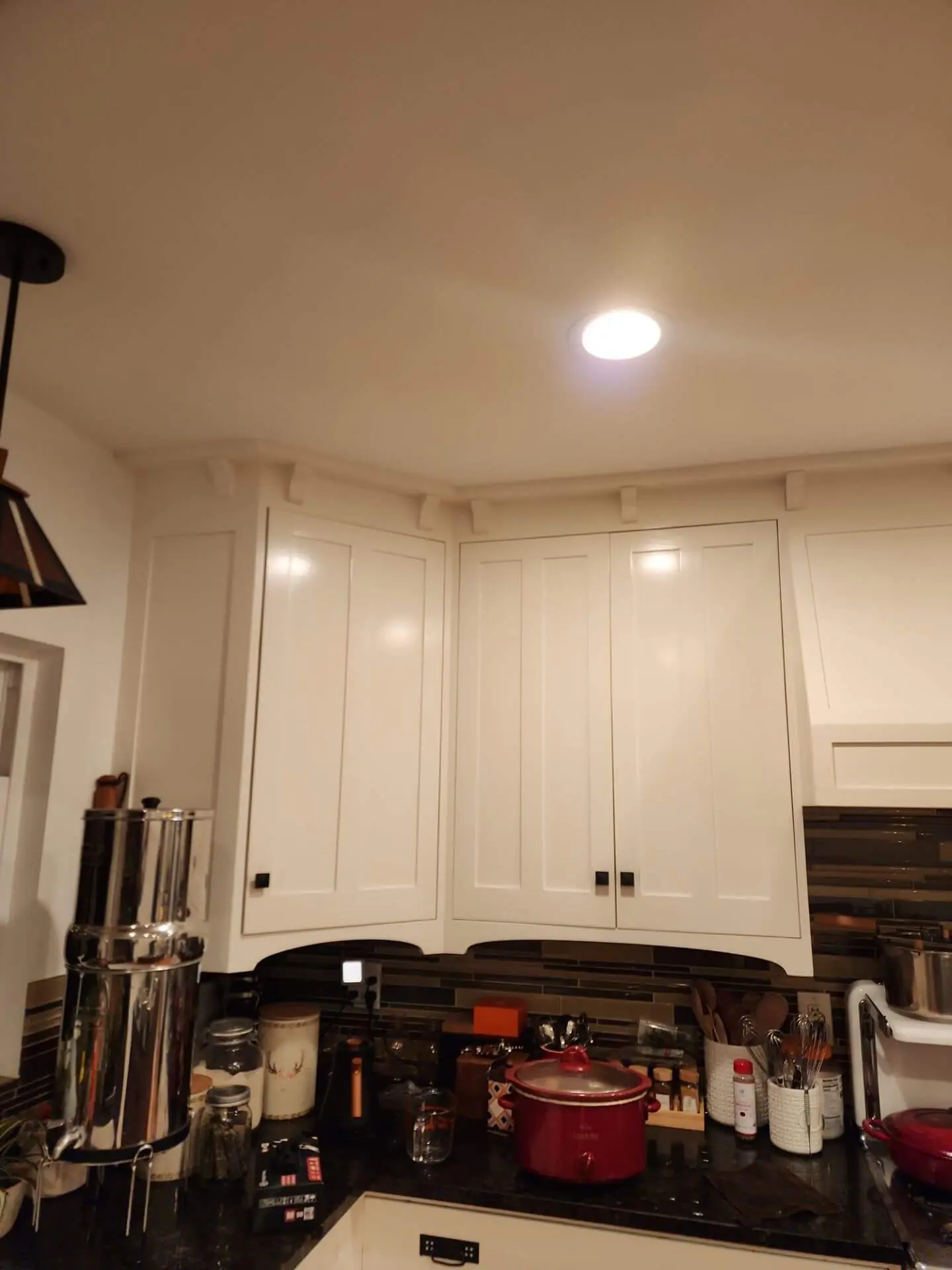 Bright kitchen interior with freshly painted white cabinets and trim, showcasing a clean interior cabinet painting project completed by Sucro Painting Contractors.