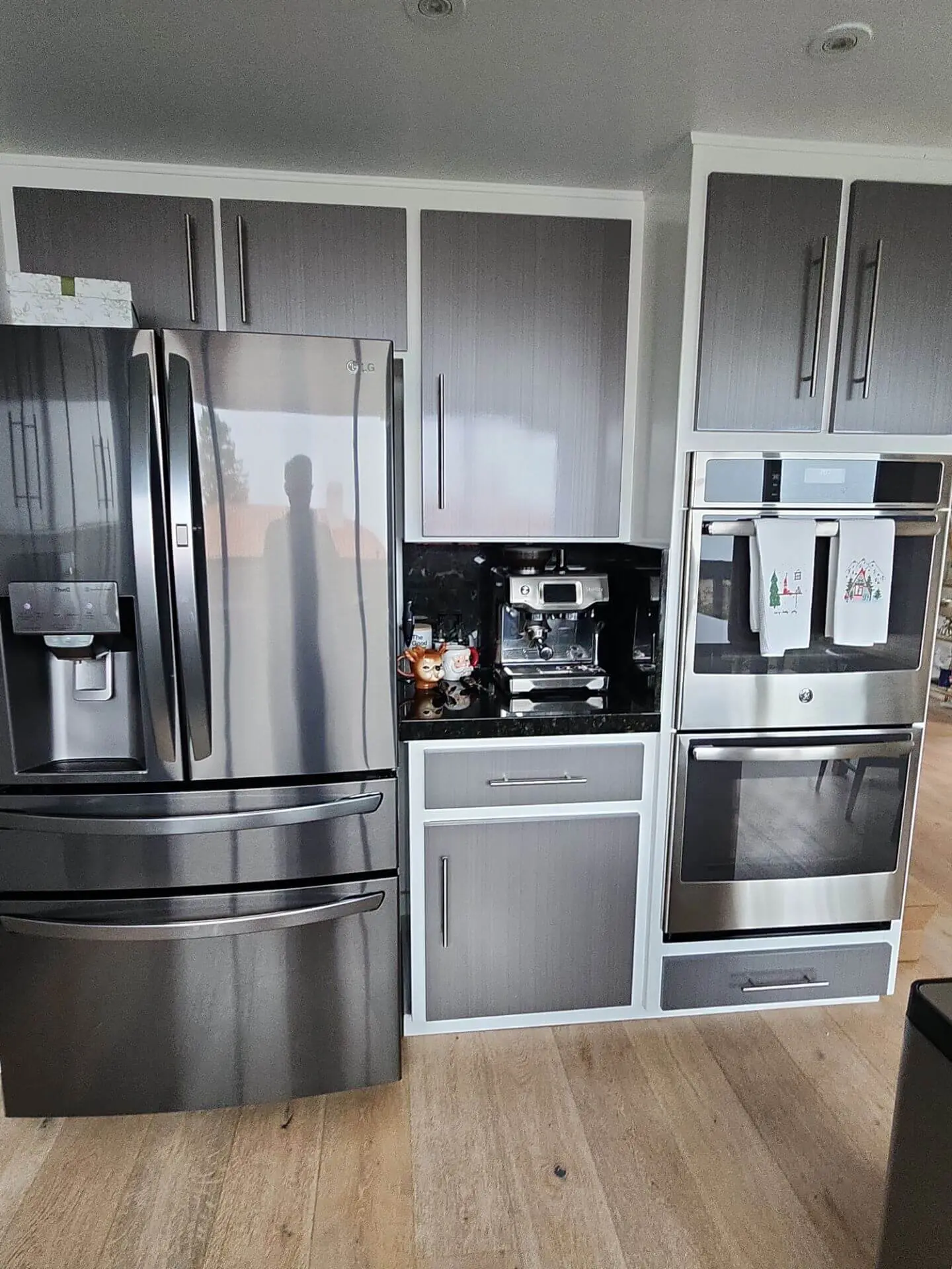 Modern kitchen with gray cabinetry, stainless steel appliances, and clean finishes, highlighting professional interior painting and cabinet work by Sucro Painting Contractors.
