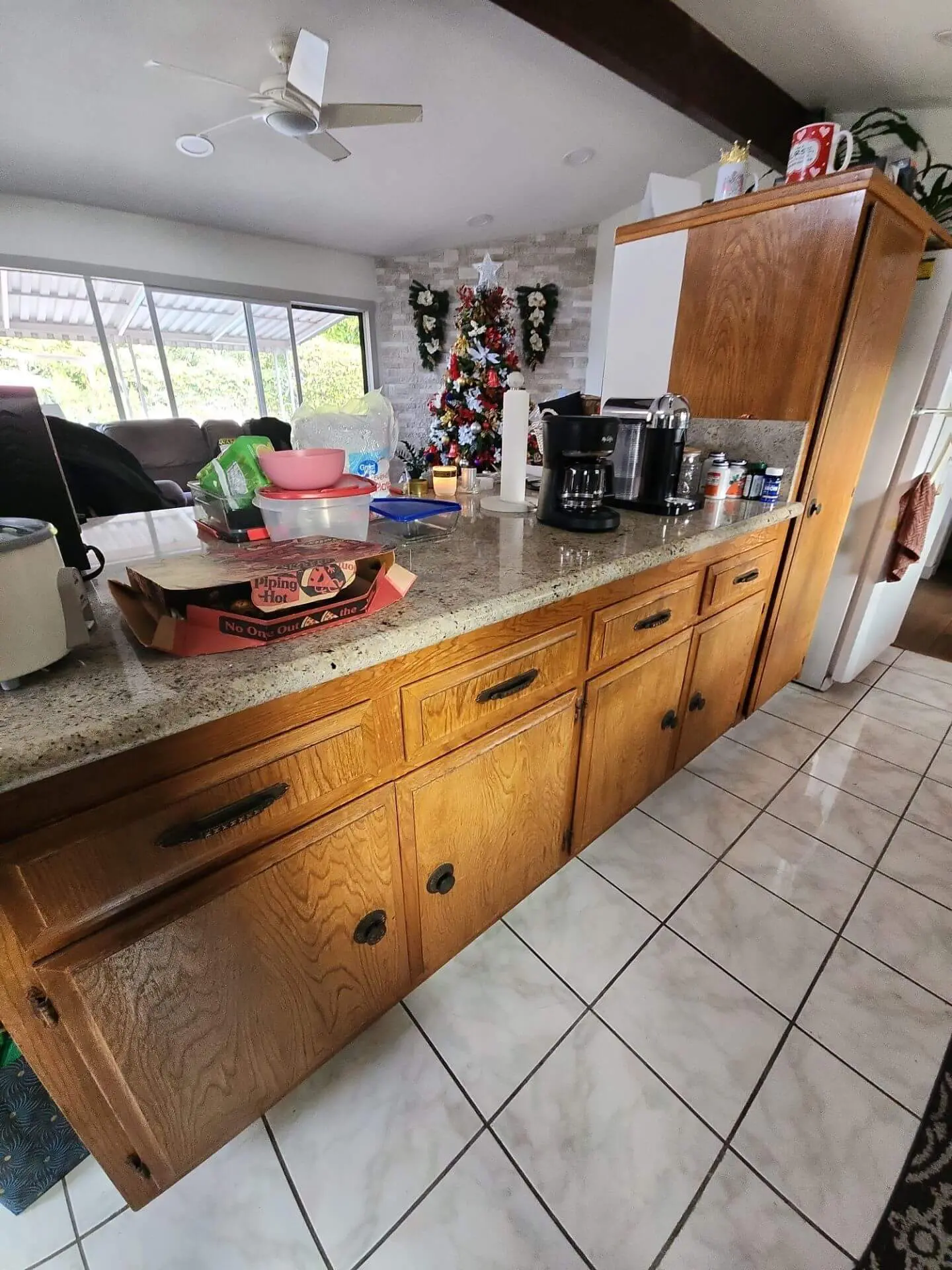 Traditional kitchen with honey oak base cabinets and granite countertops, shown before refinishing during a cabinet painting and refinishing project by Sucro Painting Contractors.