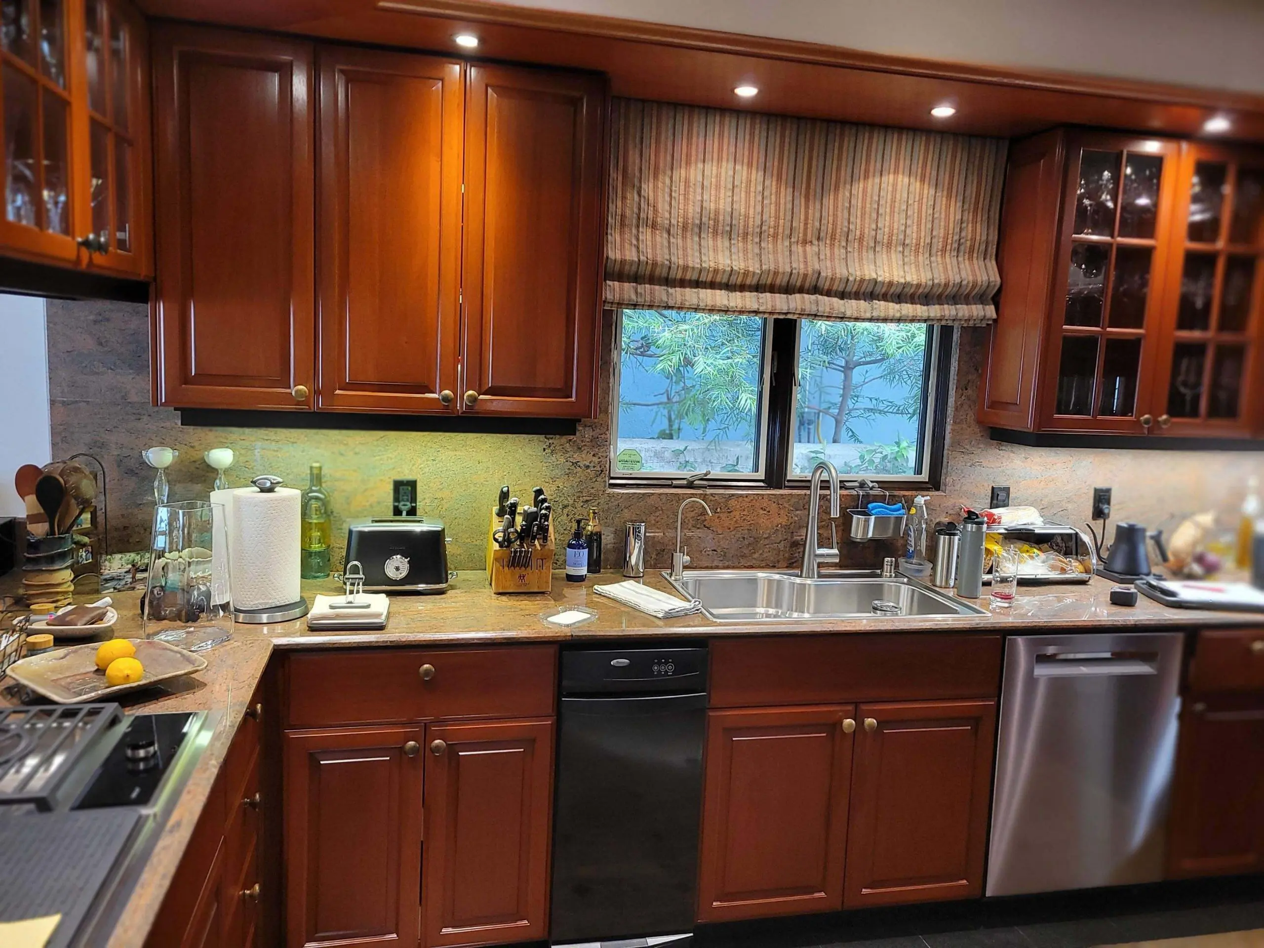 Warm, traditional kitchen featuring rich cherry wood cabinets and granite countertops, shown before refinishing as part of a professional cabinet painting and refinishing project by Sucro Painting Contractors.