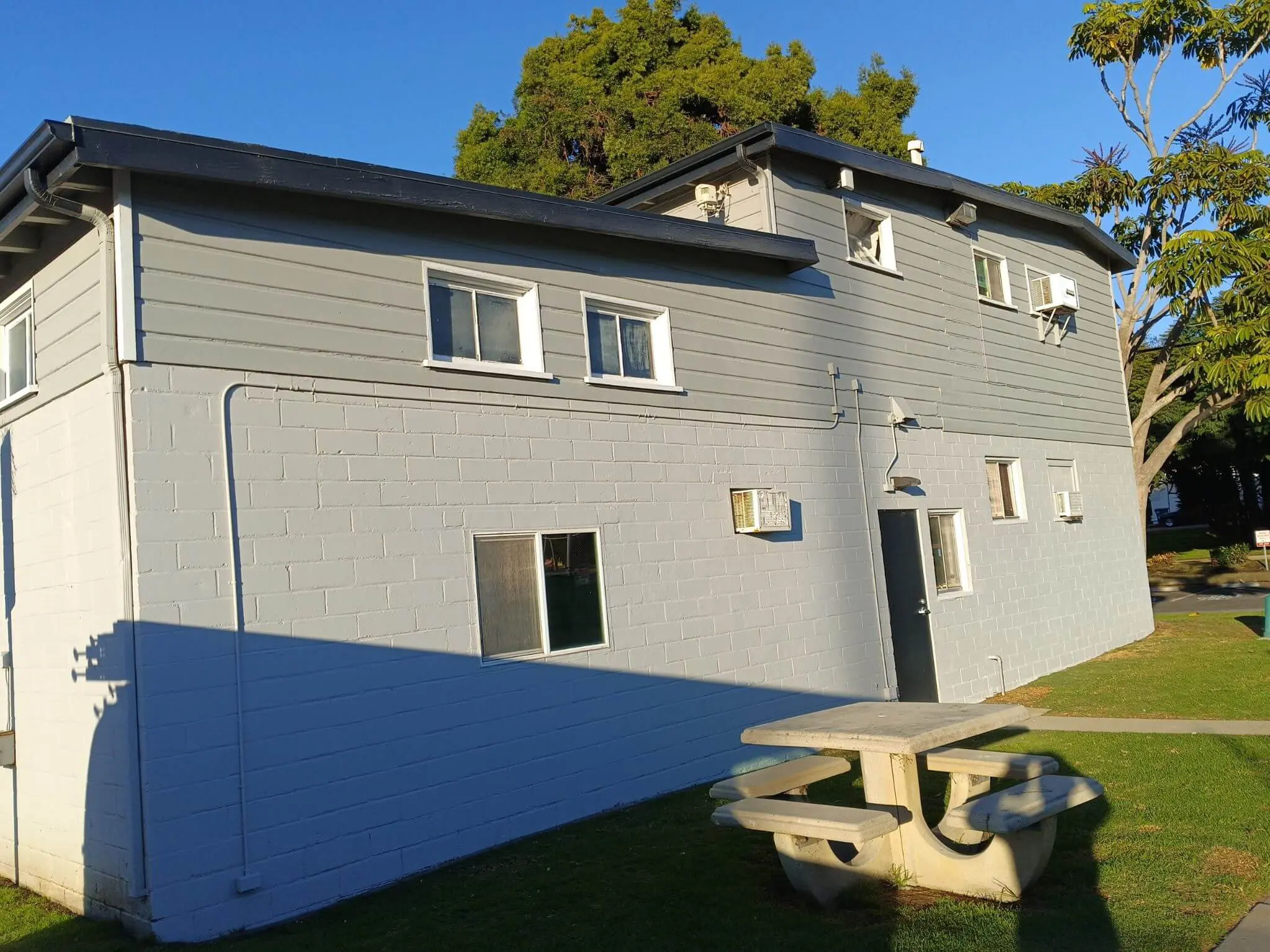 Freshly painted gray apartment building exterior with clean siding and masonry work, completed by Sucro Painting Contractors for a durable, modern finish.