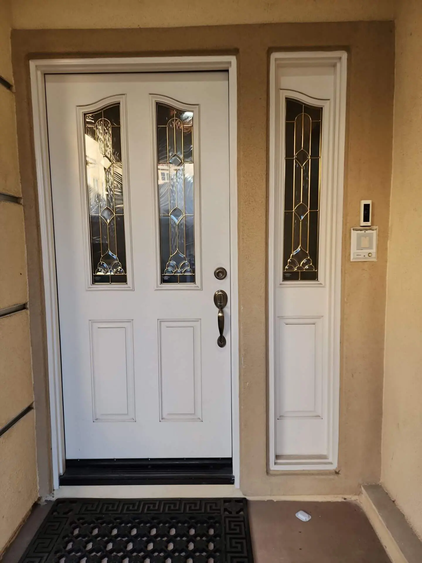 Freshly painted front entry door with clean white trim and glass panels, completed by Sucro Painting Contractors to enhance curb appeal and exterior detail.
