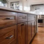 Kitchen island with wood cabinets showing cabinet refinishing vs replacement decision in a modern home