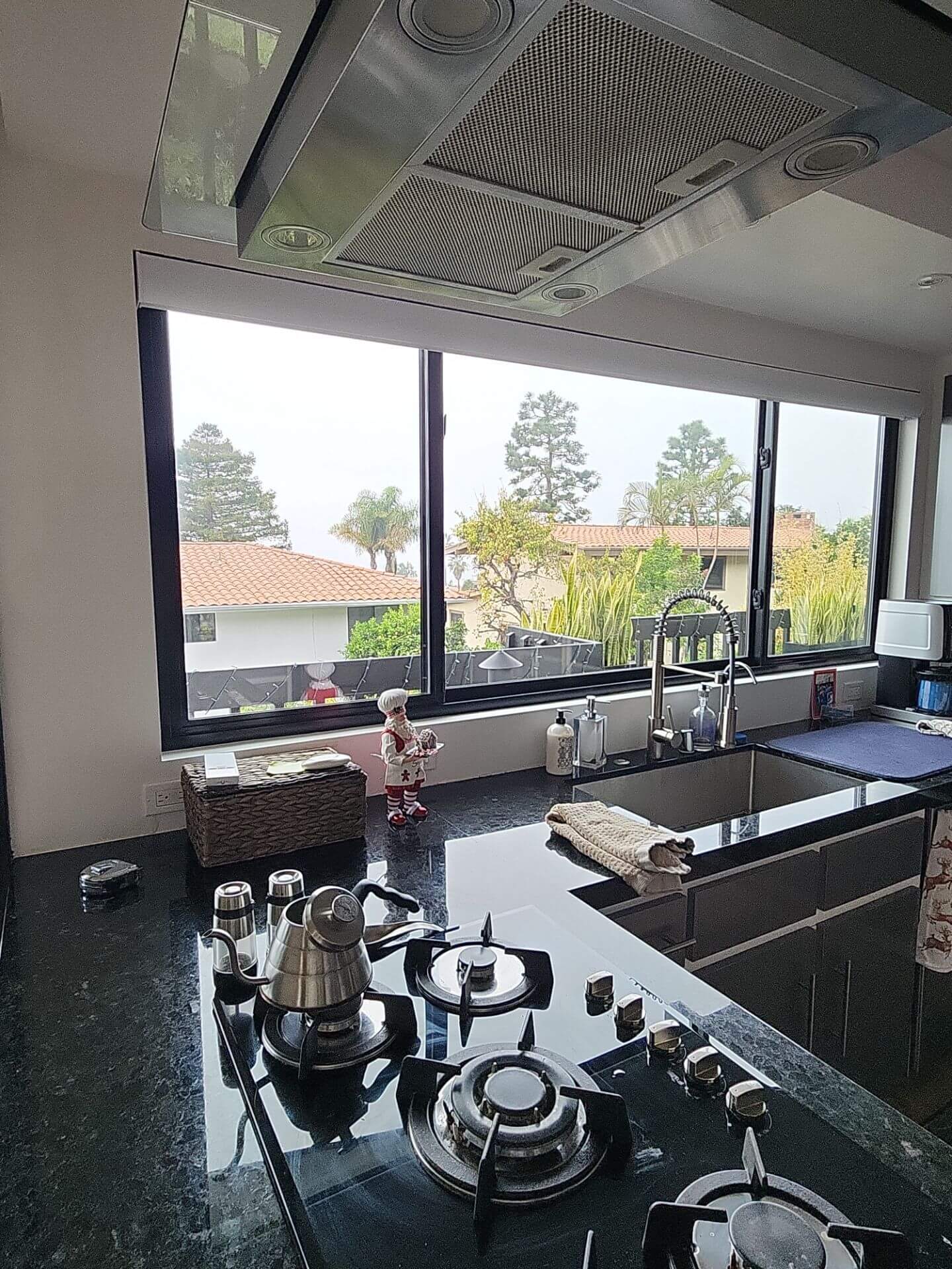 Modern kitchen interior with black countertops, stainless range hood, and clean wall finishes, showcasing detailed interior painting work completed by Sucro Painting Contractors.