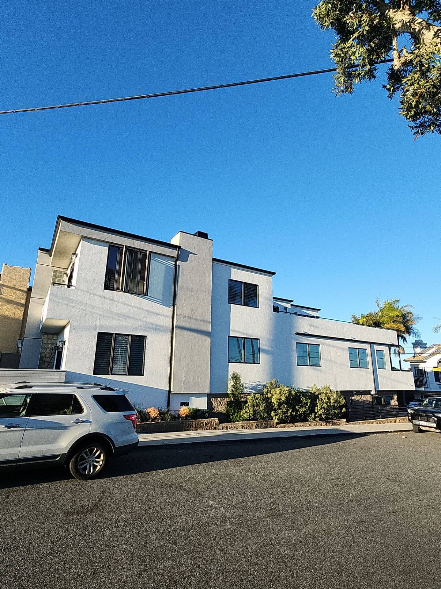 Freshly painted modern multi-unit exterior with clean white stucco and crisp trim, showcasing professional exterior painting work by Sucro Painting Contractors.