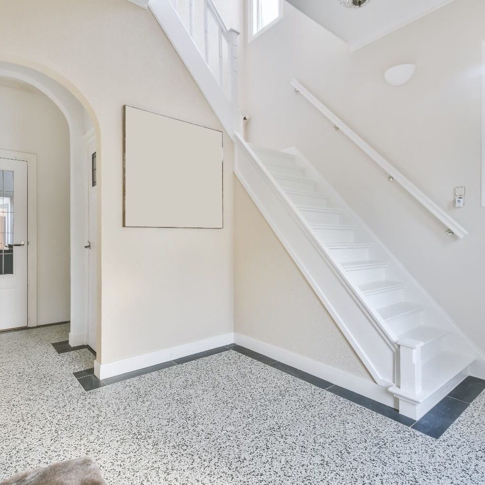 Bright residential entryway with white staircase, arched doorway, and freshly painted walls completed by Sucro Painting Contractor.