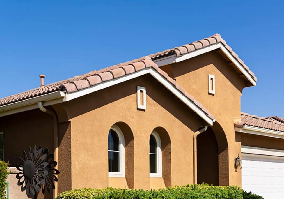 Stucco exterior on a Southern California home with clay tile roof and arched windows