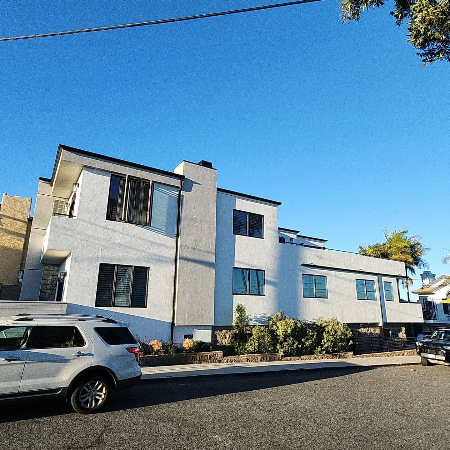 Freshly painted modern multi-unit exterior with clean white stucco and crisp trim, showcasing professional exterior painting work by Sucro Painting Contractors.
